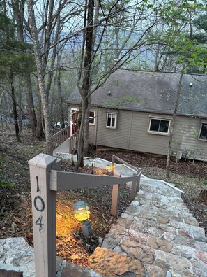A house with a stone pathway leading to a wooden gate marked '104'. - Bent Tree Family 2BR - Hot Tub, Mountain View Deck, Pool, Golf, Lake & Fish (Jasper)