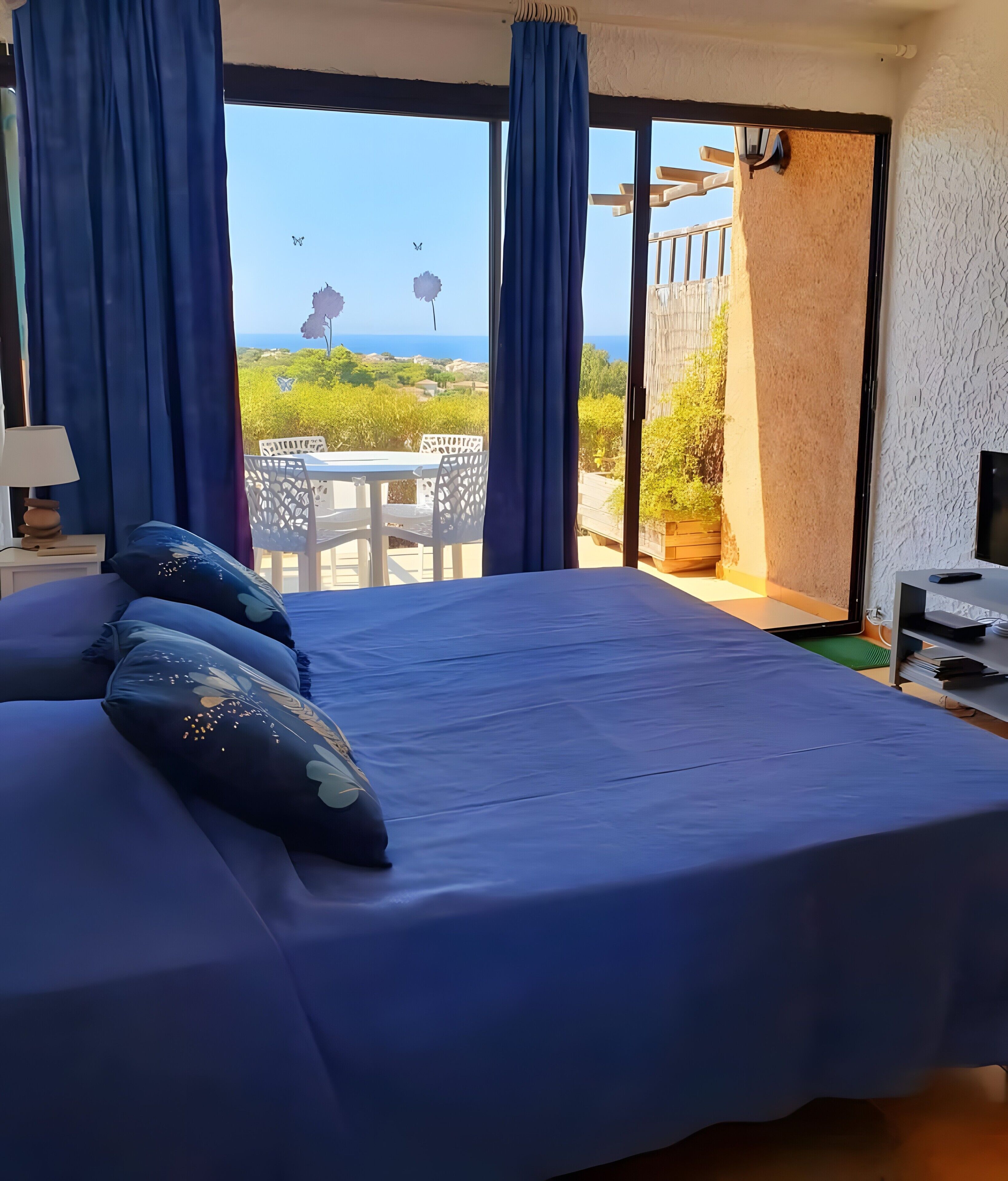 Une chambre avec un grand lit, une télévision et une vue sur l’extérieur.