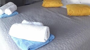Una camera d'albergo con un letto, un comodino, uno specchio e un quadro appeso al muro.