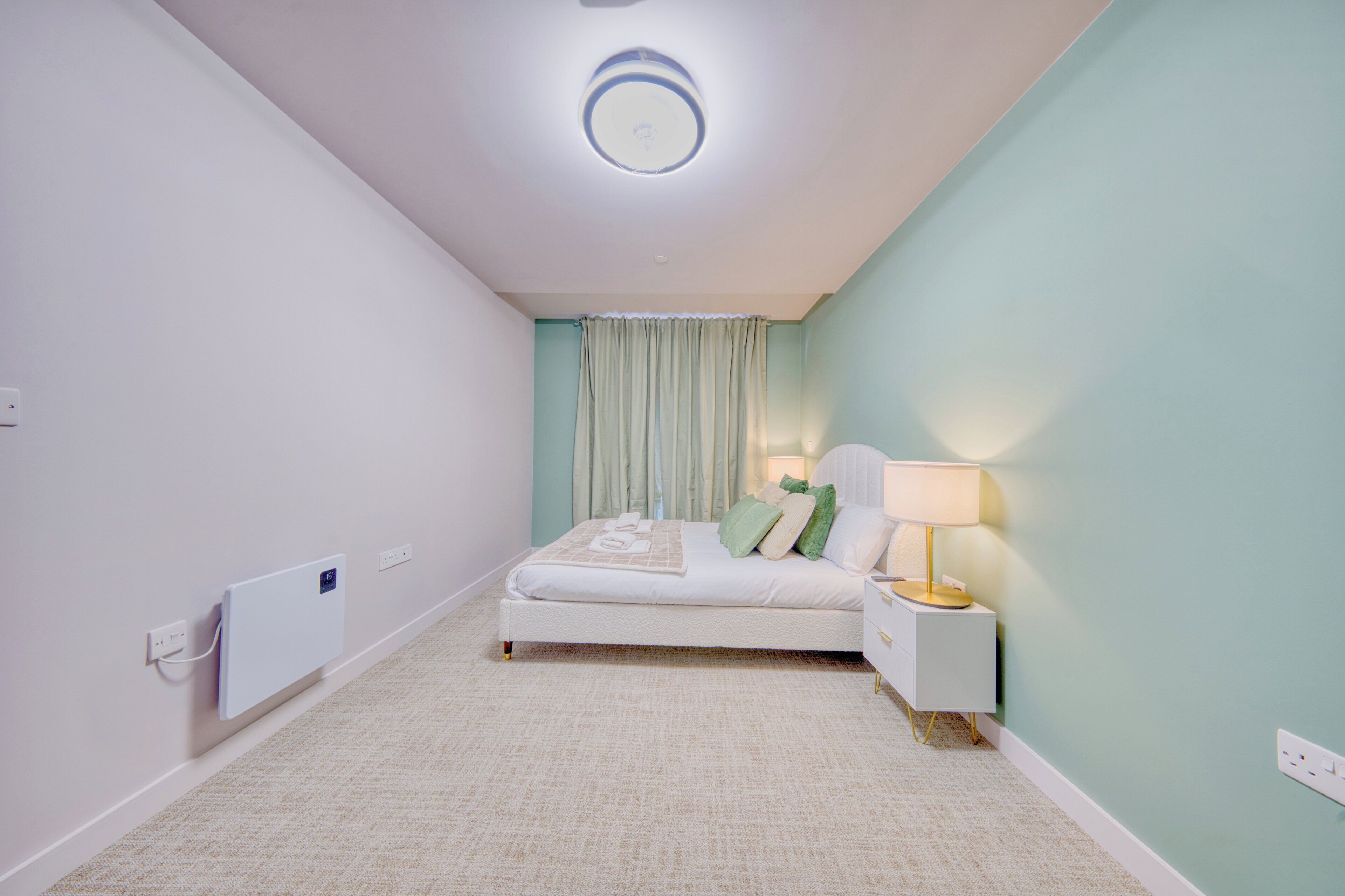 Una camera da letto con un letto, un comodino, una lampada e un lampadario.