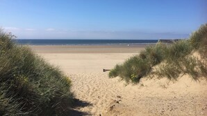 A beach with sand dunes and a clear sky.