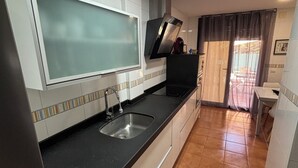 Una cocina con un ventanal grande, un fregadero y una estufa.