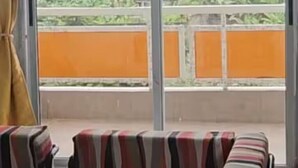 A room with large windows, a striped sofa, and a yellow curtain. - Résidence au 2 Plateaux 3 Chambres (Abidjan)