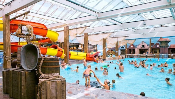 An indoor swimming pool with multiple slides and a glass ceiling. - Chalet in Biddinghuizen, Pool Facilities (Biddinghuizen)