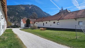 A building with a gravel path, a wooden bench, and a soccer goal.