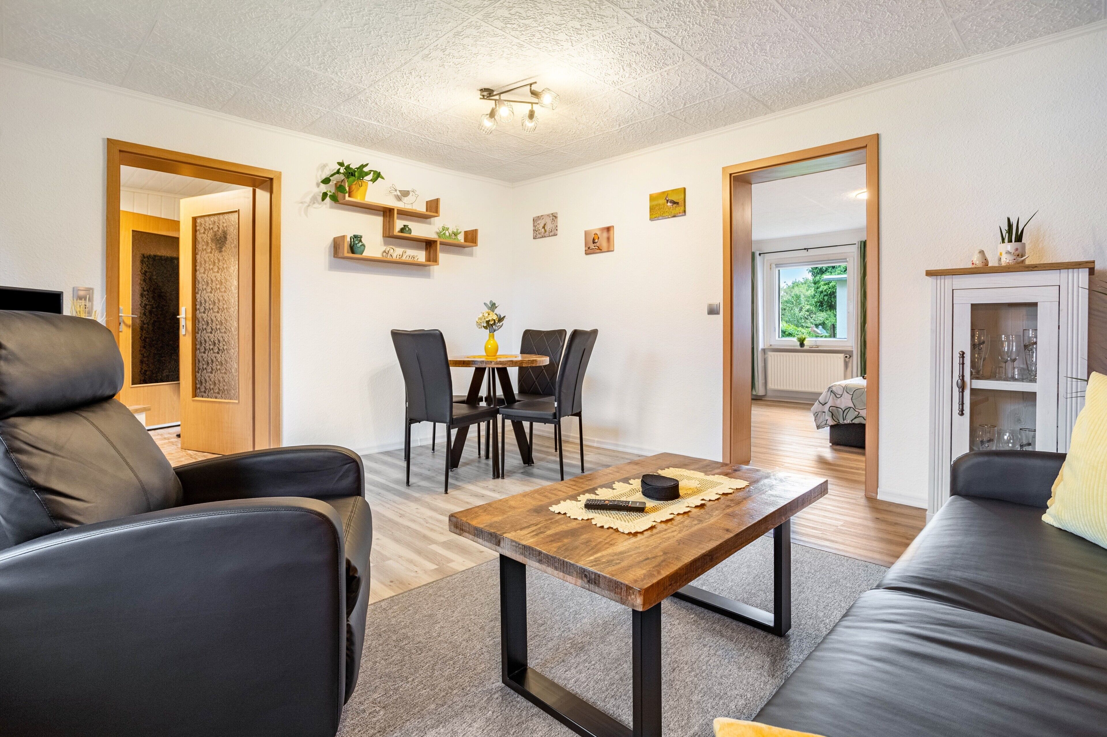 Ein modernes Wohnzimmer mit einer Couch, einem Couchtisch und einem Essbereich mit Stühlen.