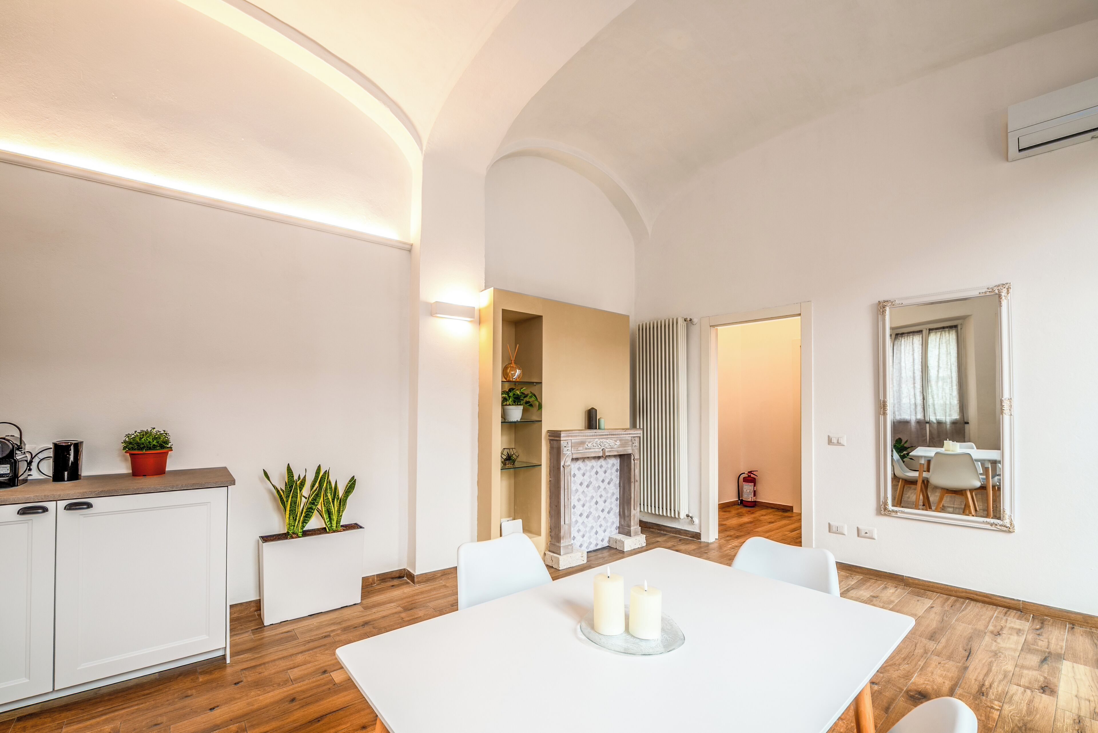 Una cocina moderna con armarios blancos, una encimera y plantas en macetas.