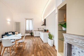 A modern apartment with a dining area, kitchen, and living space. - Volte Lake House (Arona)