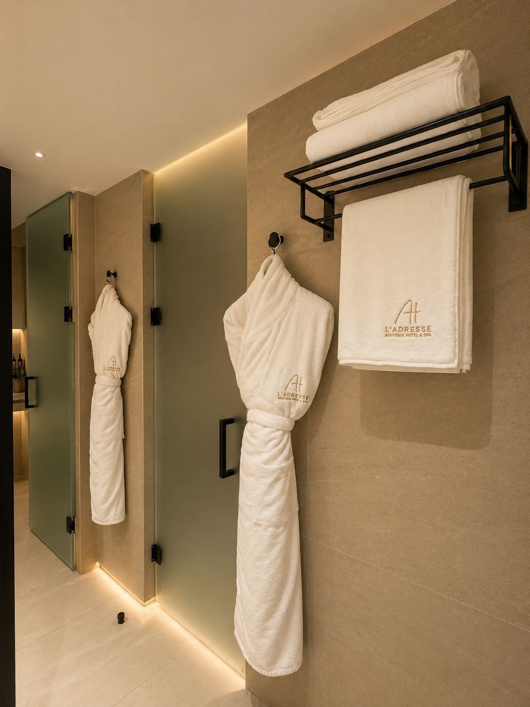 Un baño moderno con espejo, toallero y estante con una toalla doblada.