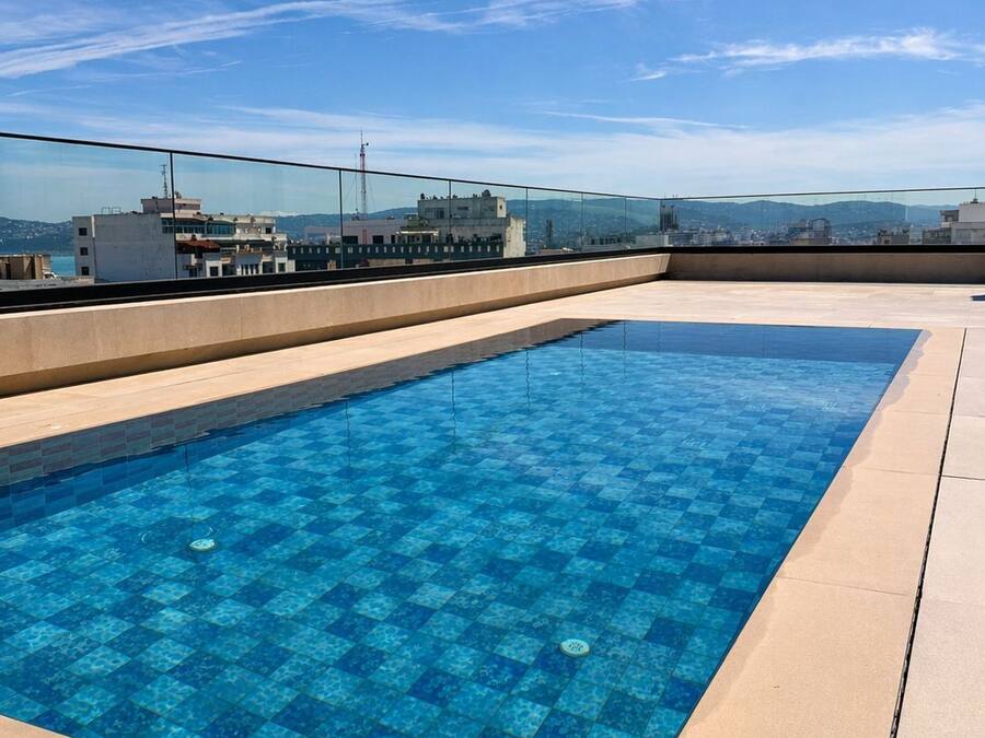 Una piscina en la azotea con vistas despejadas del paisaje urbano.