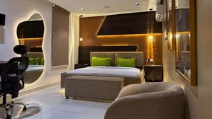 A modern bedroom with a large bed, a desk, and a chair. - The Waves Apartment (Lagos)