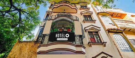 A hotel with a prominent 'HOTEL' sign, ornate balconies, and a traditional architectural style.