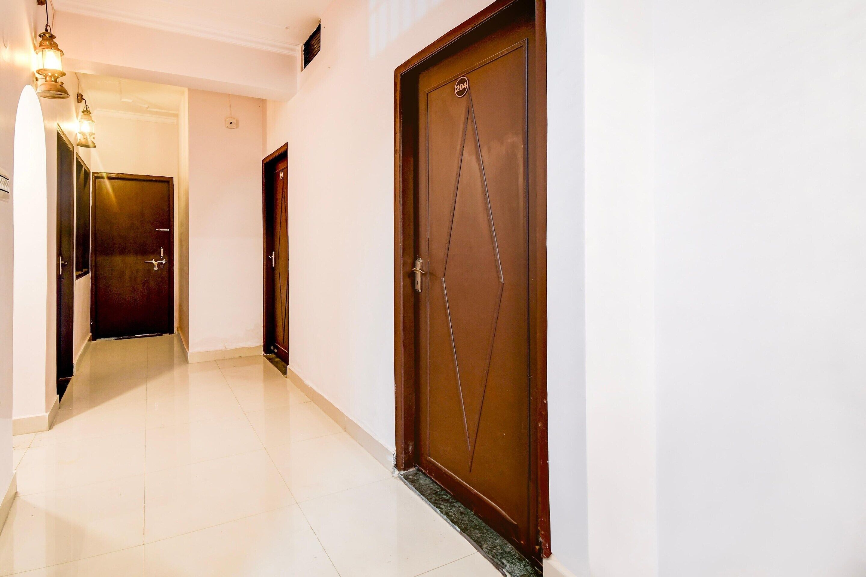 A corridor with a wooden door marked '204' and a light fixture above it.
