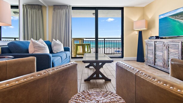 Une pièce avec un canapé, une table et une vue sur la plage.