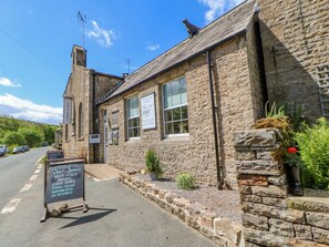Ein Steinhaus mit Schildern für eine Kunstgalerie und ein Kunsthandwerksladen.