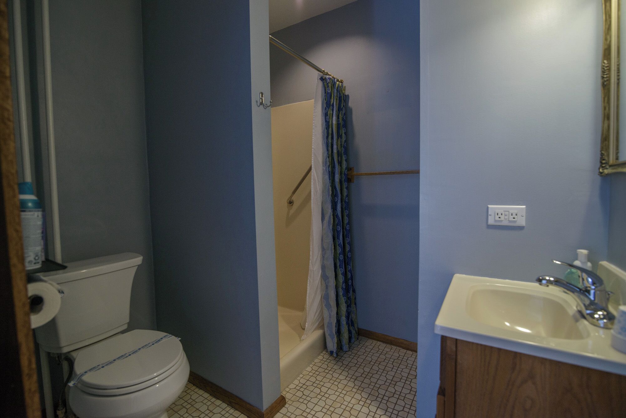 Un baño con inodoro, cortina de ducha, lavabo y espejo.
