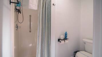 A bathroom with a shower, toilet, and a towel rack.