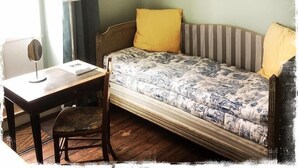 Une pièce comprenant un lit, une chaise, une table et une lampe.