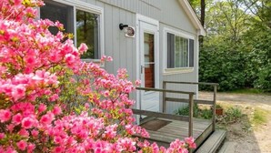 Una casa con veranda in legno, una porta e una finestra.