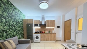 Uma cozinha compacta com máquina de lavar, micro-ondas e armários de madeira.