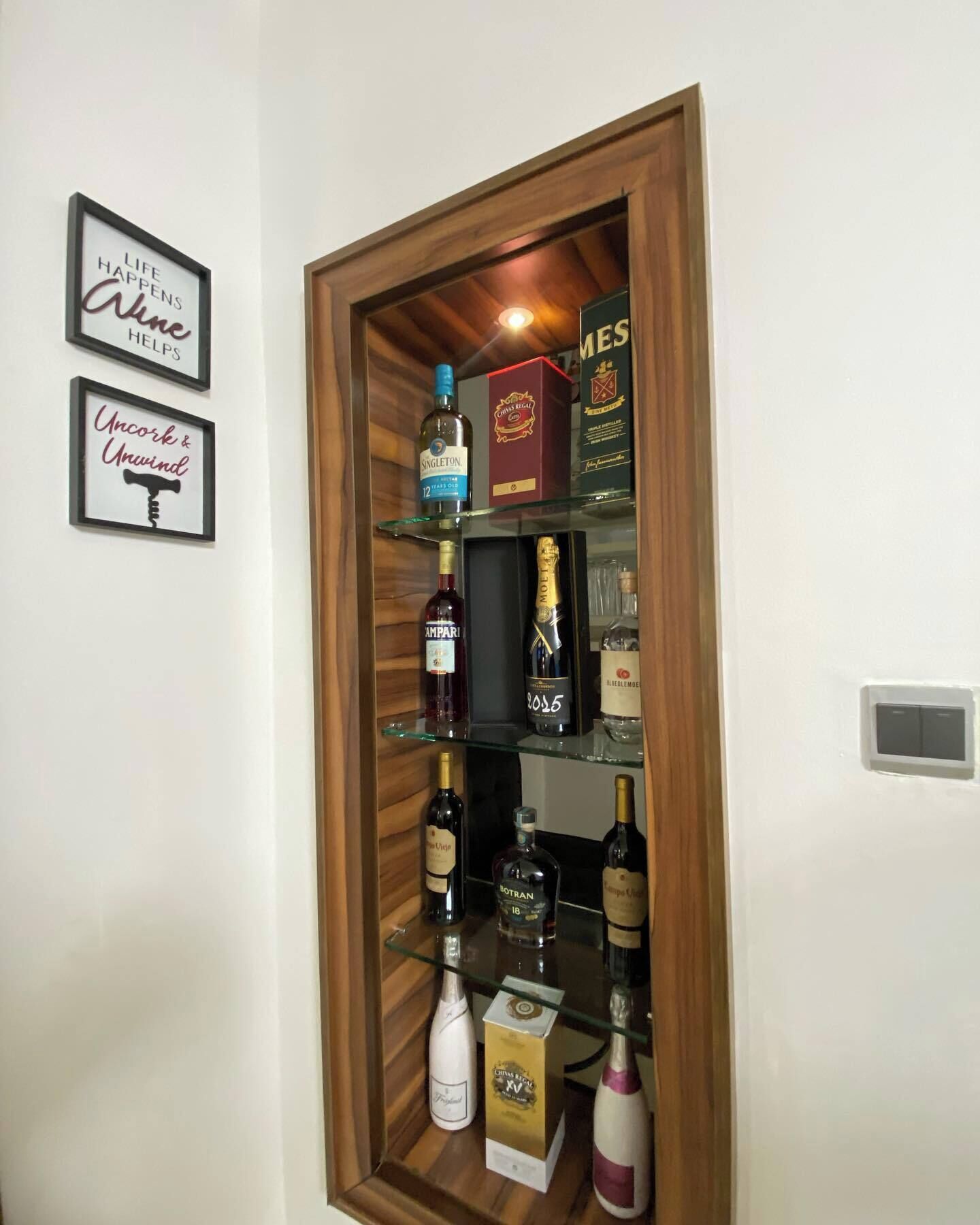 A wine rack with various bottles and a box of wine glasses.