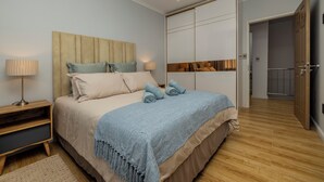 Une chambre à coucher avec un lit, une table de chevet, une lampe et une armoire.