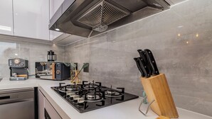 Une cuisine moderne équipée d’une cuisinière à gaz, d’une machine à café et d’un bloc à couteaux.