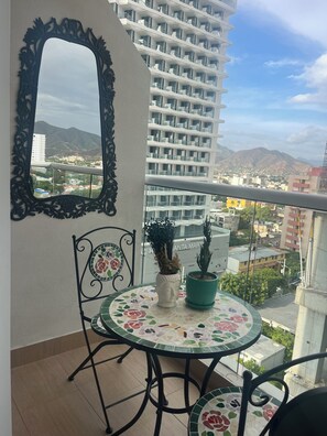 A balcony with a round table, chairs, a mirror, and potted plants. - Eira Studios Santa Marta by Xarm Apartments (Santa Marta)