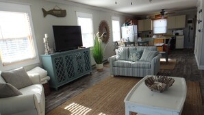 A living room with a television, sofa, and dining area.