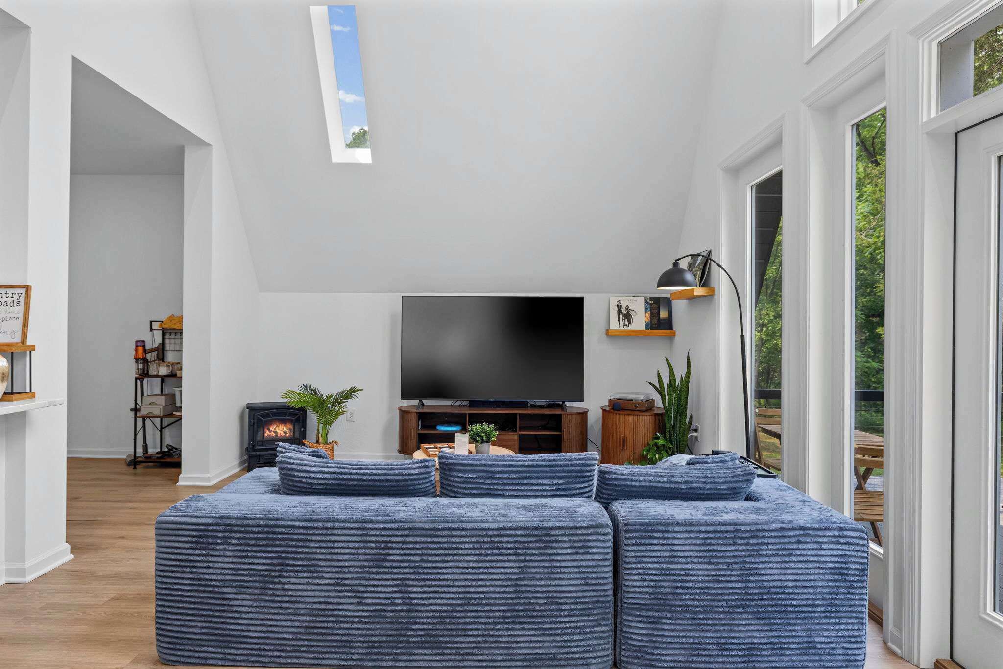 A modern living room with a sectional sofa, a flat-screen TV, and a fireplace.