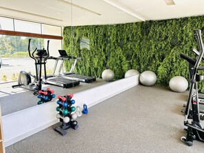 A gym with treadmills, exercise balls, and weight equipment. - Makia Beach Resort Luxo - Muro Alto-10 Piscinas (Ipojuca)