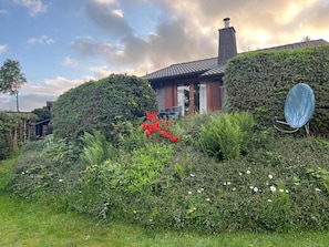 A house with a chimney, surrounded by dense greenery and a satellite dish. - Chalet 'Blockhaus Ferienzauber 3' with Shared Terrace, Private Garden and Wi-Fi (Allendorf (Eder))