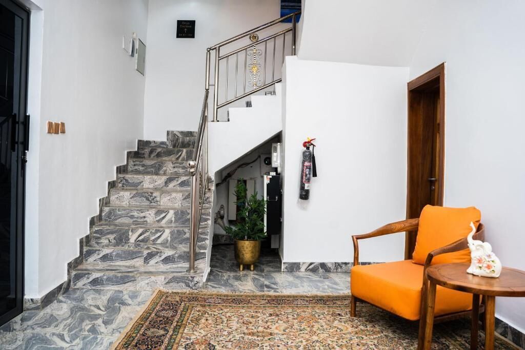 A staircase with marble steps, a wooden chair, a small round table, and a potted plant.