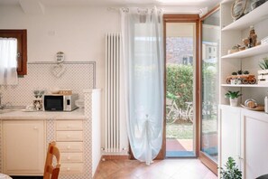A kitchen with a microwave, a tea sign, and a view of the outside. - GuestHost - Cozy 55m2 apartment, ideal for 2 people, located on the ground floor of a building with private garden and parking.The accommodation is located a stone's throw from the historic center of Lucca, a historic city that boasts symbolic places suc (Lucca)