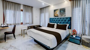 A modern bedroom with a large bed, a desk, a chair, and a small table. - Deluxe k.k Nagar Residency (Chennai)