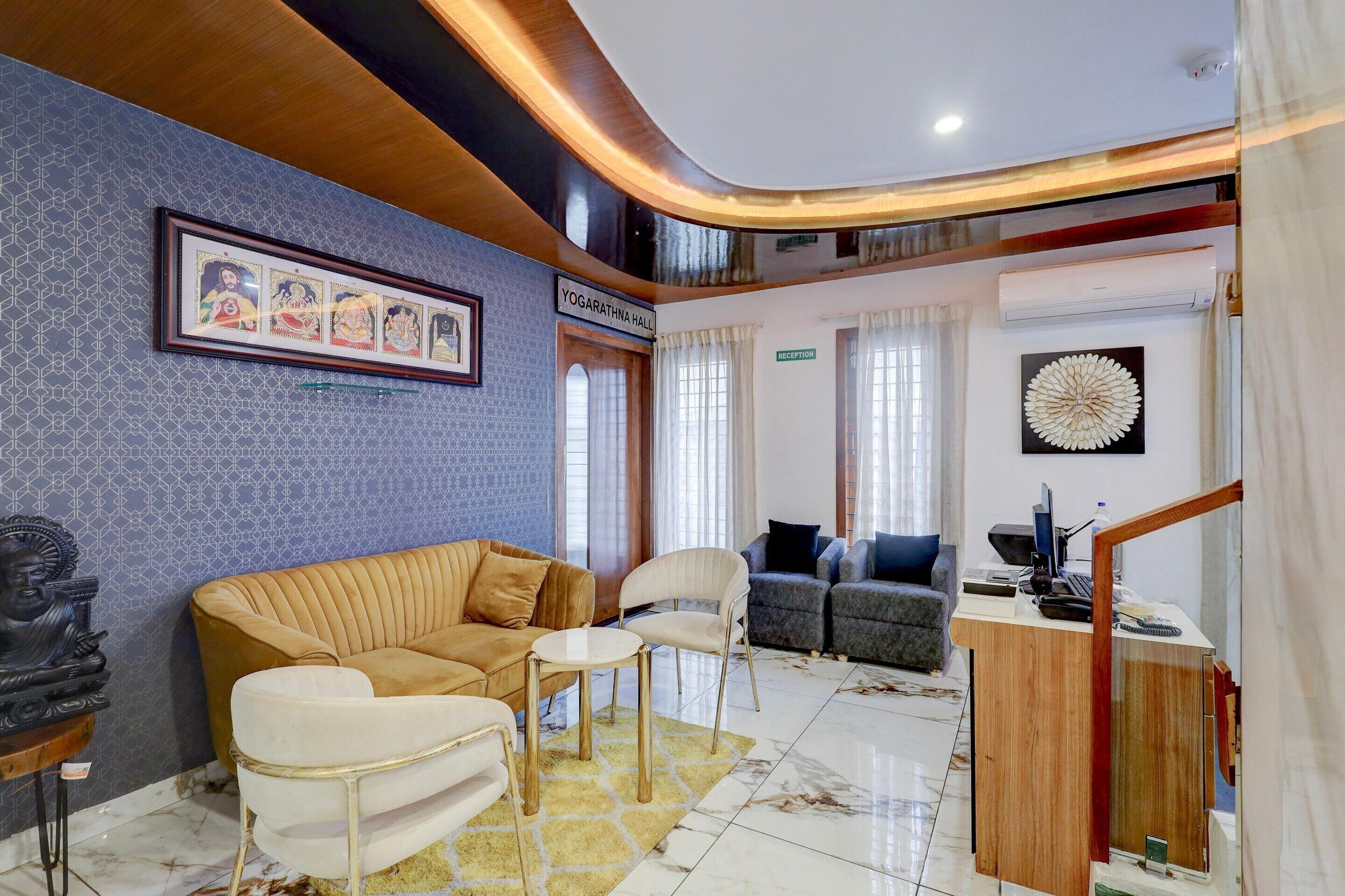 Een moderne hotellobby met een receptiebalie, een zithoek en kunstwerken aan de muren.
