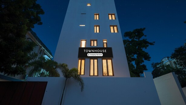 A building with a sign reading 'TOWNHOUSE' and a company-serviced logo. - Deluxe k.k Nagar Residency (Chennai)