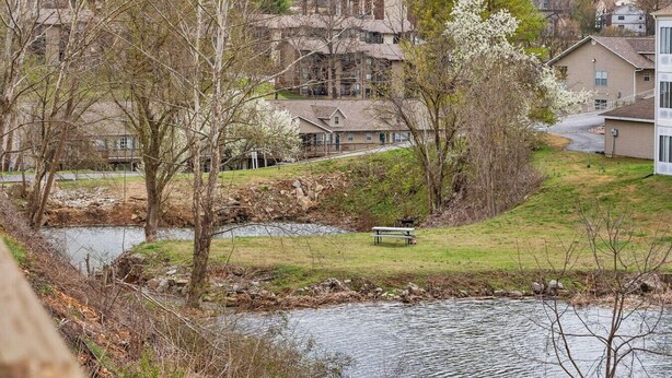 Un quartier résidentiel avec une rivière, des arbres et des maisons.