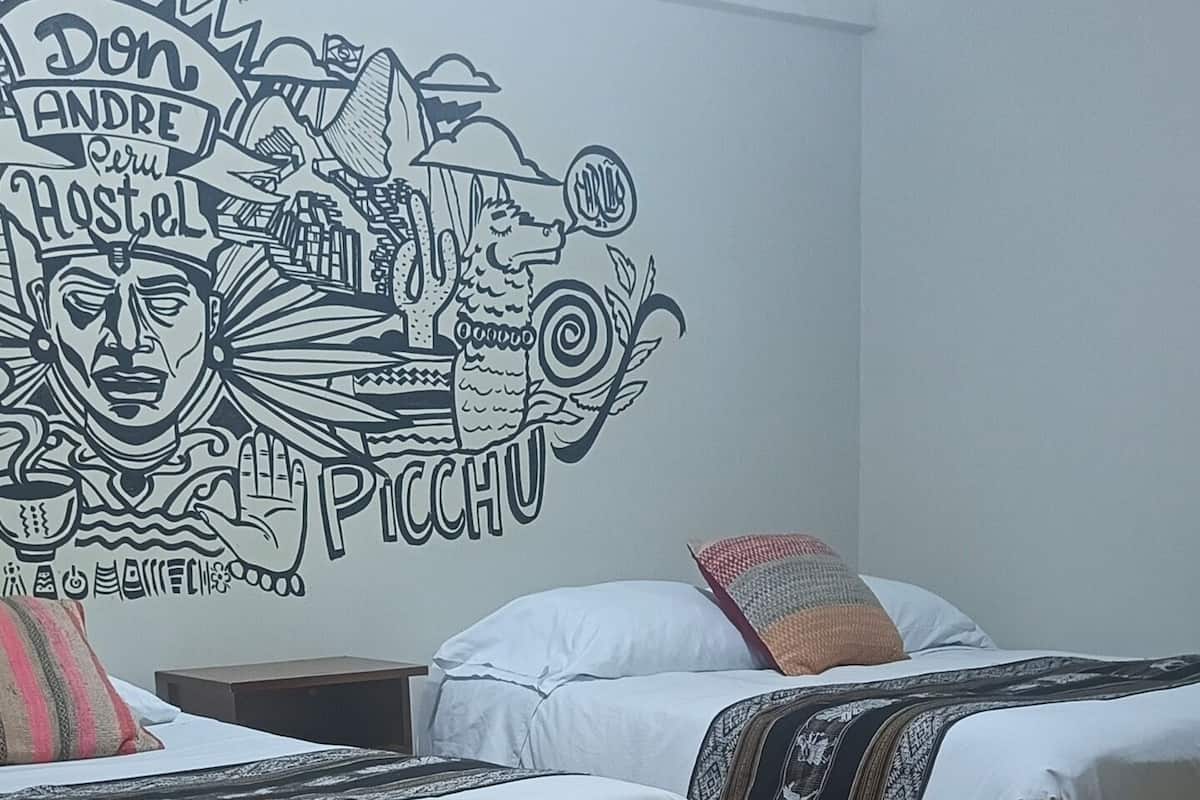 A room with two beds, a wooden floor, and a mural on the wall.