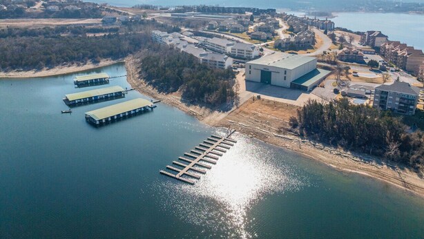 An aerial view of a coastal area with a marina, buildings, and a dock. - Luxury Lake Vacation at Emerald Pointe (Hollister)