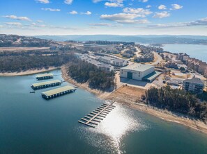 Vista aérea de una zona costera con un puerto deportivo, edificios y un muelle.