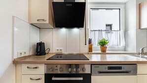 Une cuisine moderne dotée d’un four encastré, d’un lave-vaisselle et d’une hotte noire.