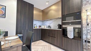 Eine moderne Küche mit dunklen Holzschränken, einer Marmor-Spritzschutzleiste und einem Siemens-Ofen.