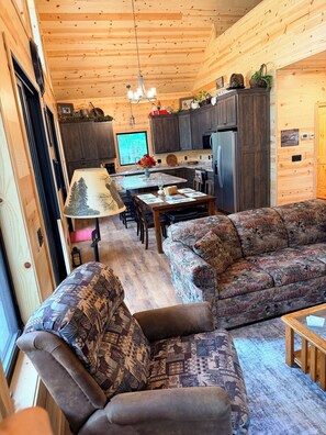 A cozy interior with a sofa, dining table, and kitchen area.
