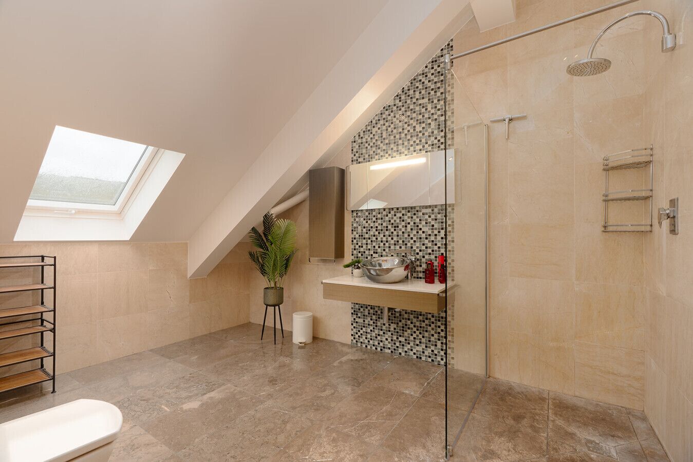 A modern bathroom with a skylight, a glass shower enclosure, and a marble floor.