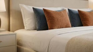A neatly made bed with a headboard, a bedside table with a lamp, and a wall with two framed artworks. - Prime Central 2BR Apartment Covent Garden (London)