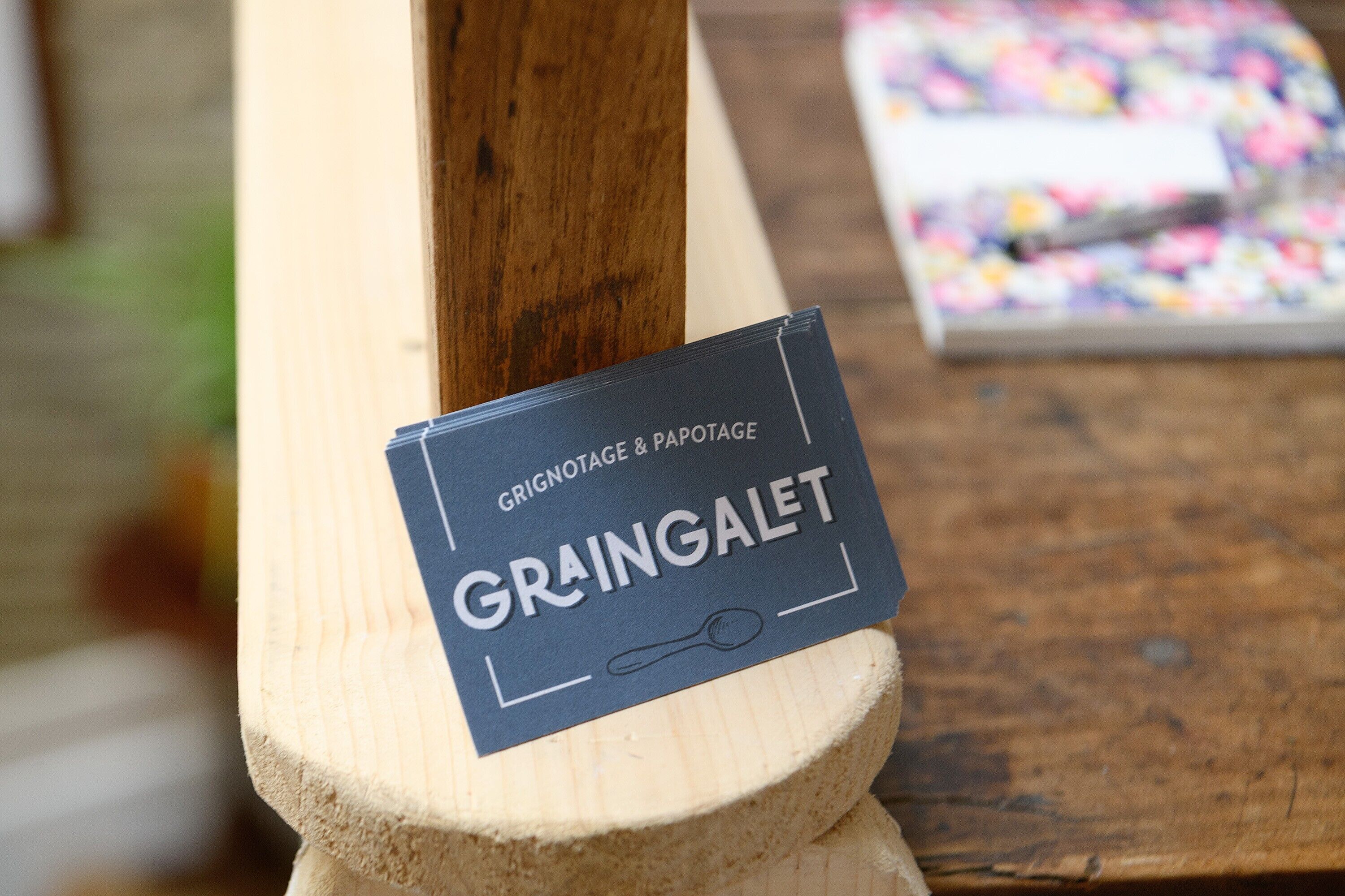 A wooden table with a sign that reads 'GRINGALET' and a blurred background.