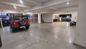 Un vaste espace de stationnement intérieur, avec un véhicule rouge garé au premier plan.