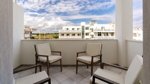 A balcony with two chairs, a tiled floor, and a view of buildings in the background. - Holiday Home 'Casa Anisia 4 Posti' with Sea View, Wi-Fi and Air Conditioning (Otranto)