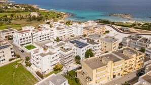A coastal residential area with multi-story buildings, a clear view of the sea, and a road leading to the beach. - Holiday Home 'Casa Anisia 4 Posti' with Sea View, Wi-Fi and Air Conditioning (Otranto)
